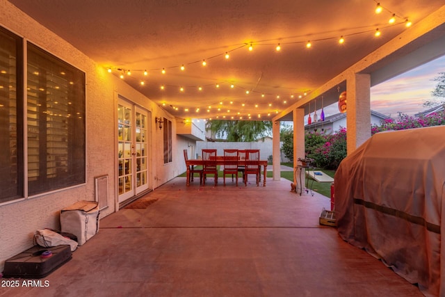 view of patio with outdoor dining area, french doors, fence, and a grill