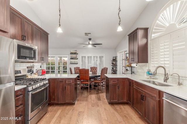 kitchen with a sink, a peninsula, visible vents, and stainless steel appliances