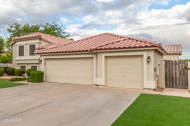 mediterranean / spanish house featuring stucco siding, concrete driveway, a garage, and fence