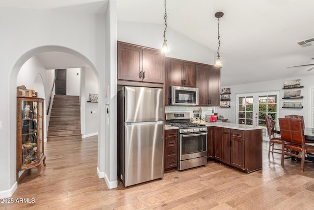 kitchen with visible vents, stainless steel appliances, a peninsula, light wood finished floors, and lofted ceiling