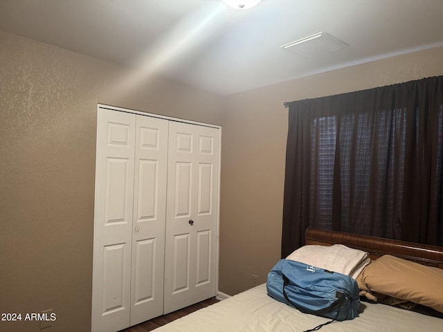 bedroom with a closet and dark hardwood / wood-style flooring