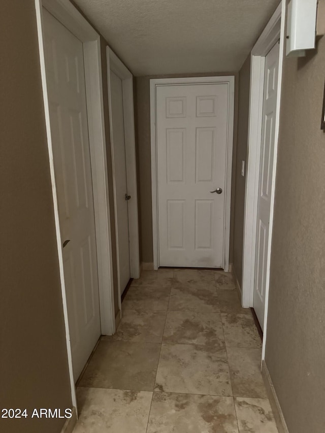 corridor featuring a textured ceiling