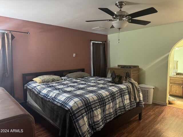 bedroom with ceiling fan, wood-type flooring, and connected bathroom