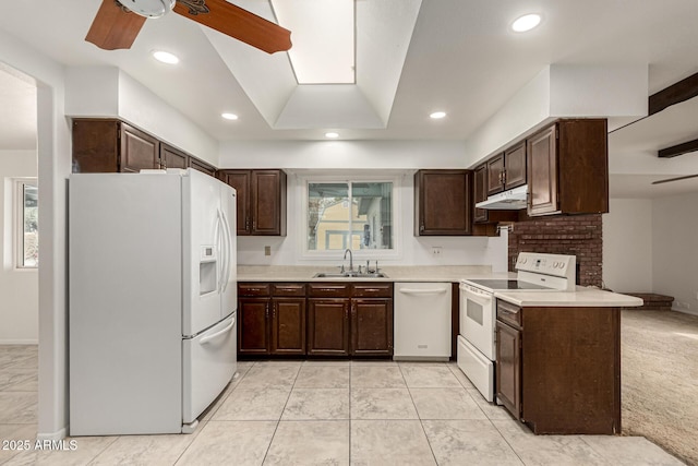 kitchen featuring light countertops, a sink, dark brown cabinetry, white appliances, and under cabinet range hood