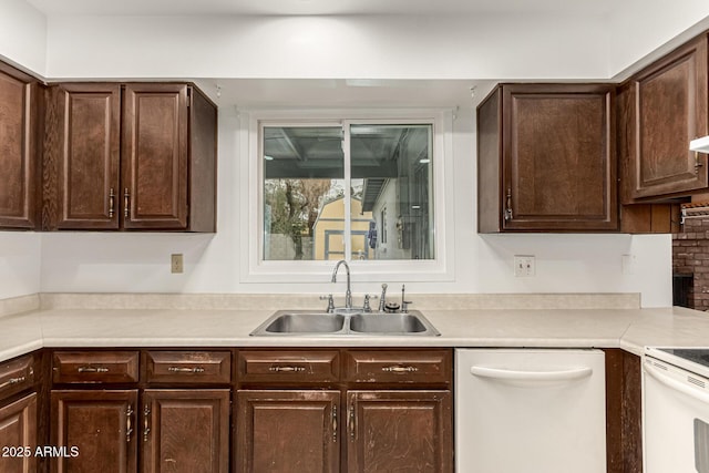 kitchen featuring dark brown cabinetry, light countertops, dishwasher, and a sink