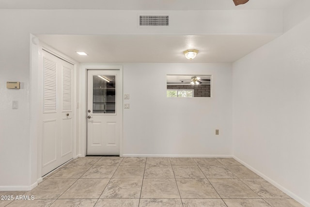 interior space featuring visible vents, ceiling fan, baseboards, and light tile patterned floors