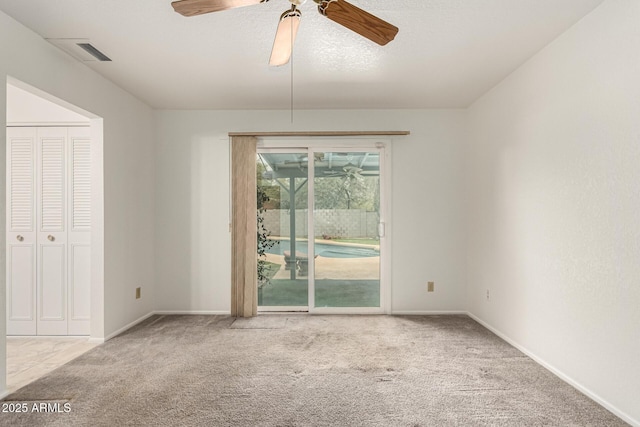 spare room with ceiling fan, carpet, and baseboards