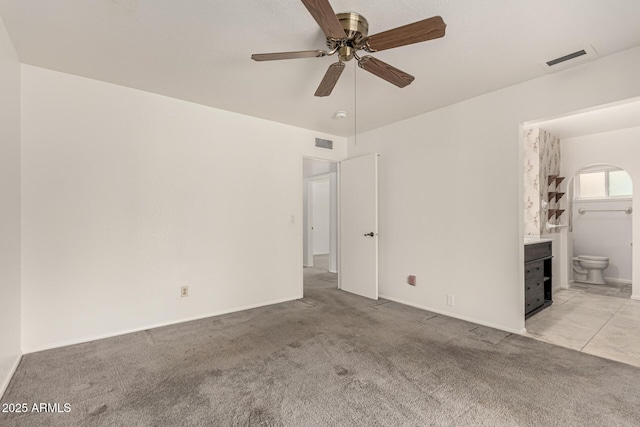 spare room with light carpet, ceiling fan, and visible vents