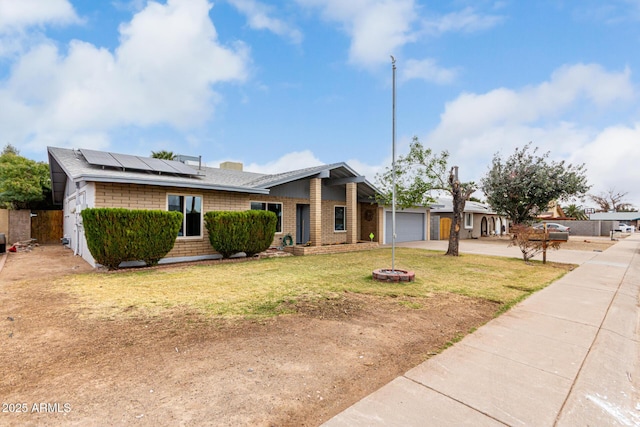 mid-century home with an attached garage, solar panels, brick siding, concrete driveway, and a front lawn