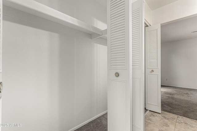 walk in closet with light carpet