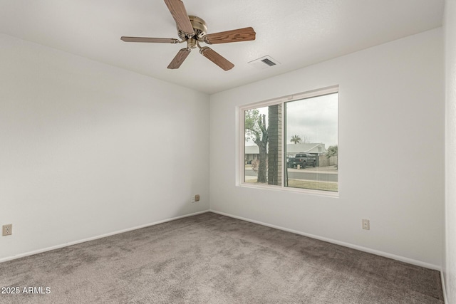 empty room with carpet floors, visible vents, baseboards, and a ceiling fan