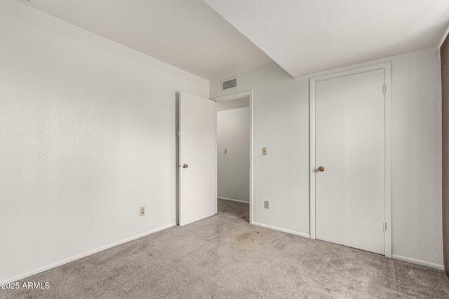 unfurnished bedroom with baseboards, visible vents, and carpet flooring