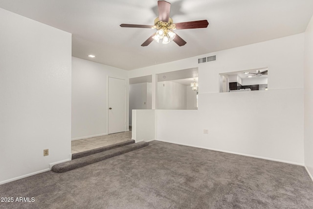 spare room with baseboards, carpet floors, visible vents, and a ceiling fan