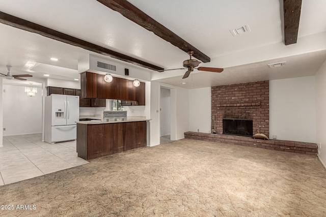 kitchen with white refrigerator with ice dispenser, visible vents, dark brown cabinets, and light colored carpet