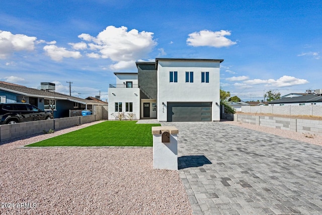 view of front of house featuring cooling unit, a garage, a balcony, and a front lawn