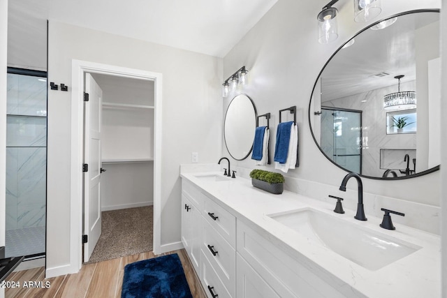 bathroom with hardwood / wood-style floors, vanity, and walk in shower