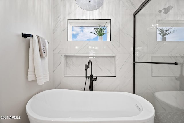 bathroom with a tub to relax in and plenty of natural light