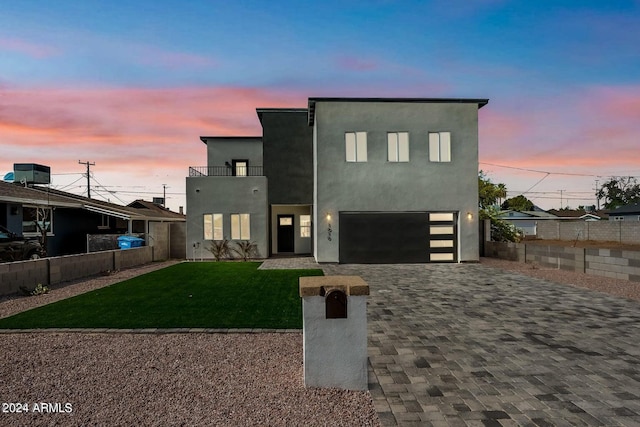 contemporary house featuring a lawn, central air condition unit, and a garage