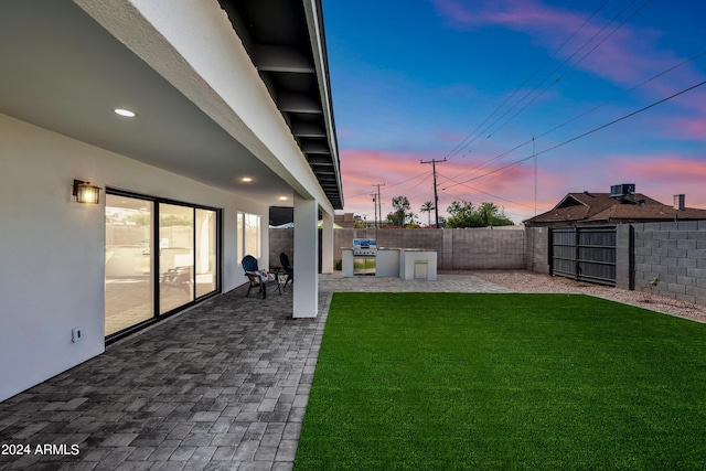 yard at dusk featuring a patio