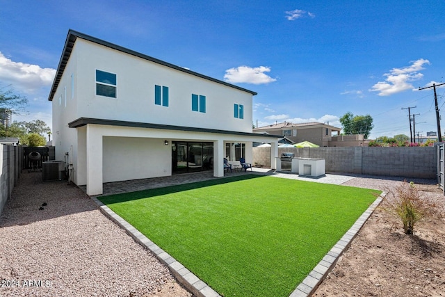 rear view of house with a lawn, a patio area, and central AC unit