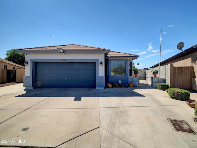 ranch-style home featuring a garage, driveway, a tile roof, and stucco siding