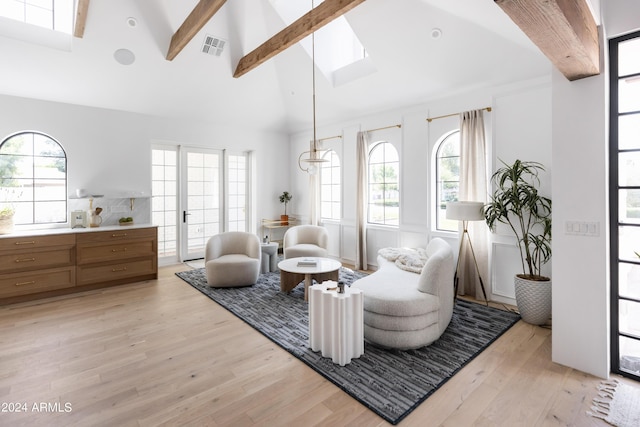 living area with light hardwood / wood-style flooring, beamed ceiling, french doors, and high vaulted ceiling