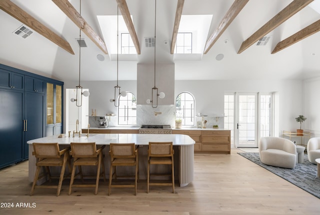 kitchen featuring blue cabinetry, paneled built in fridge, beamed ceiling, and hanging light fixtures