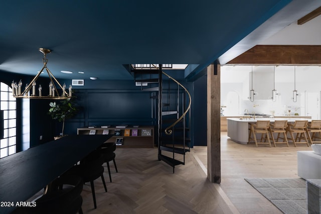 dining room featuring parquet flooring and a chandelier