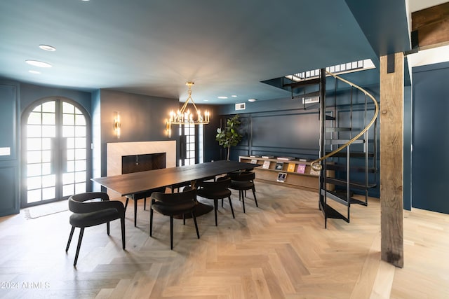 dining space featuring a chandelier, a premium fireplace, and light parquet flooring