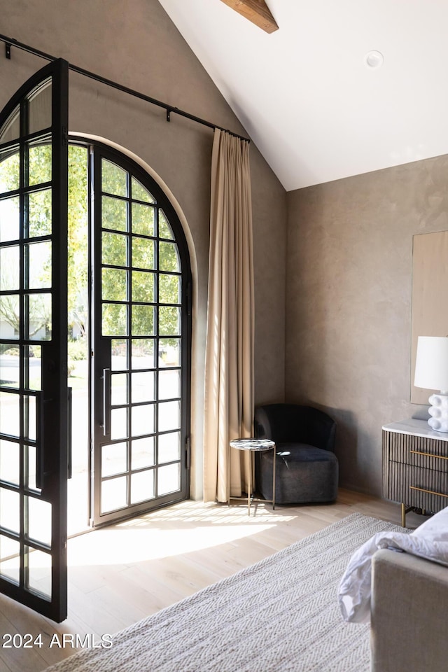 unfurnished bedroom with light wood-type flooring, lofted ceiling, and multiple windows