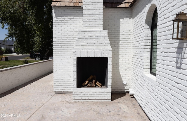 view of side of home featuring an outdoor fireplace