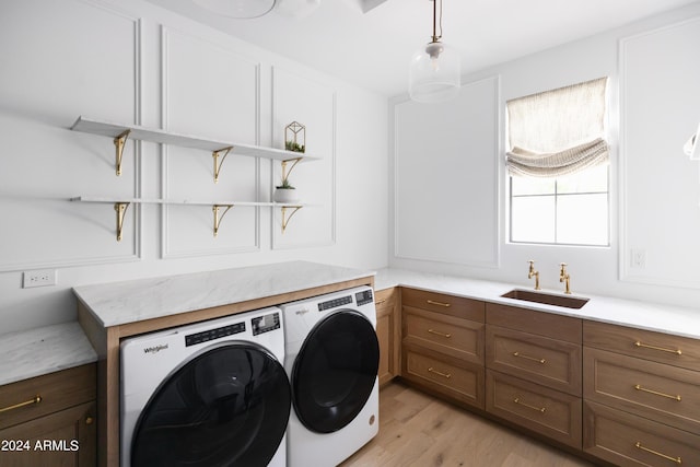 washroom featuring washer and dryer, light wood-type flooring, and sink