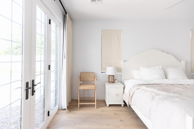 bedroom with french doors and light wood-type flooring