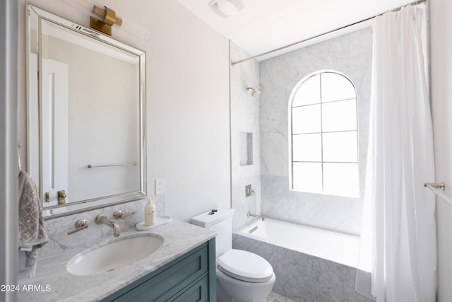 full bathroom featuring vanity, tiled shower / bath combo, and toilet