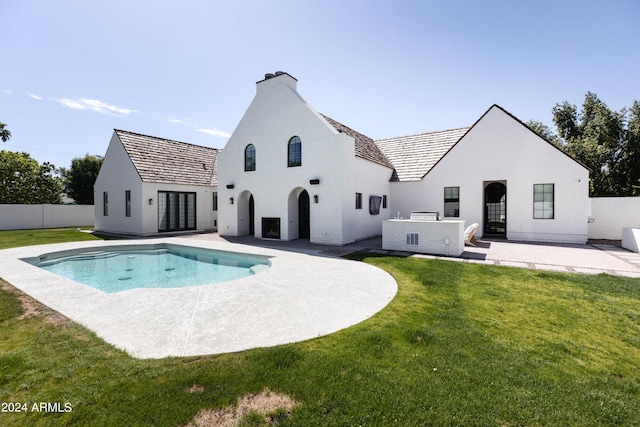 back of house with a fenced in pool, a yard, and a patio