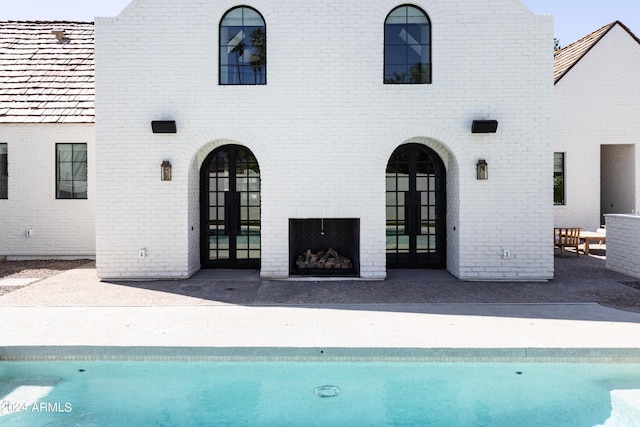 back of house with a fireplace, french doors, and a patio area