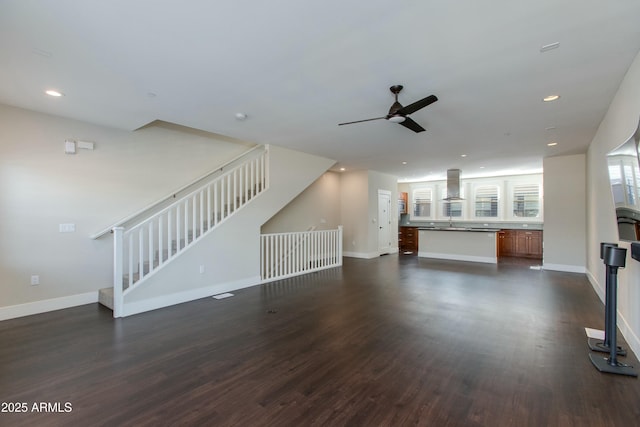 unfurnished living room with dark wood-type flooring, ceiling fan, and sink