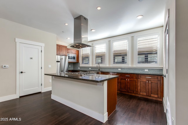 kitchen featuring appliances with stainless steel finishes, a center island, island range hood, and sink