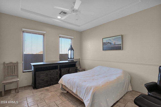 bedroom featuring ceiling fan and a tray ceiling