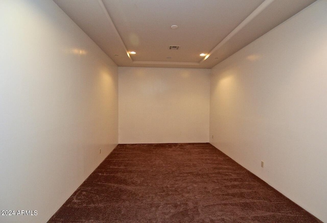 carpeted spare room with a tray ceiling