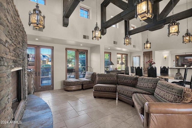 living room featuring a stone fireplace and a high ceiling