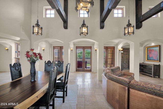 dining space featuring french doors and a towering ceiling