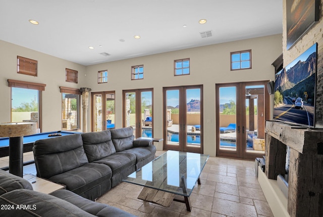 living room featuring french doors, a towering ceiling, a healthy amount of sunlight, and billiards