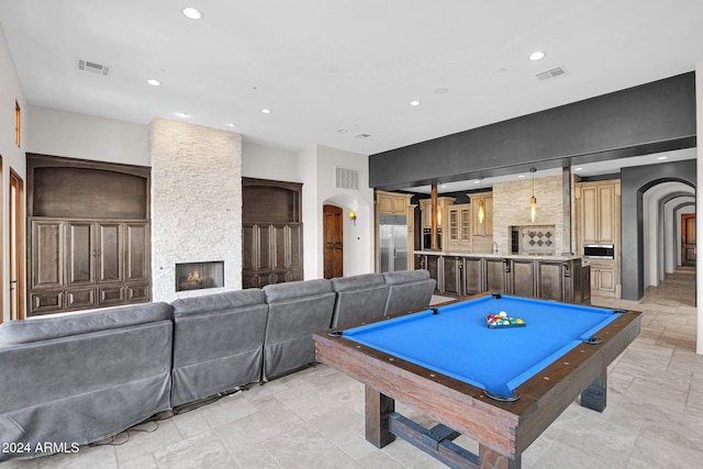 playroom with a fireplace and pool table