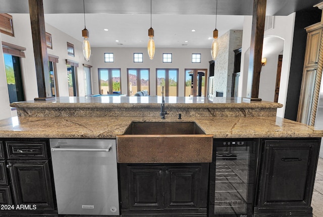 kitchen featuring hanging light fixtures, a wealth of natural light, beverage cooler, and sink