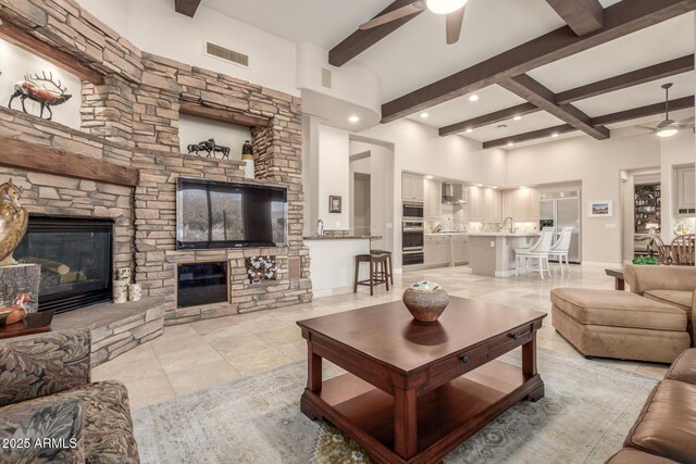 3205 S Ponderosa Dr, Gold Canyon, AZ 85118 - living room featuring a fireplace, light tile patterned floors, a ceiling fan, visible vents, and beam ceiling
