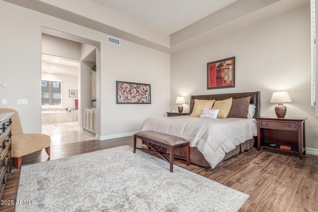 3205 S Ponderosa Dr, Gold Canyon, AZ 85118 - bedroom with visible vents, baseboards, connected bathroom, and wood finished floors