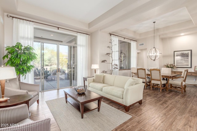 3205 S Ponderosa Dr, Gold Canyon, AZ 85118 - living area featuring a tray ceiling, wood finished floors, an inviting chandelier, and visible vents
