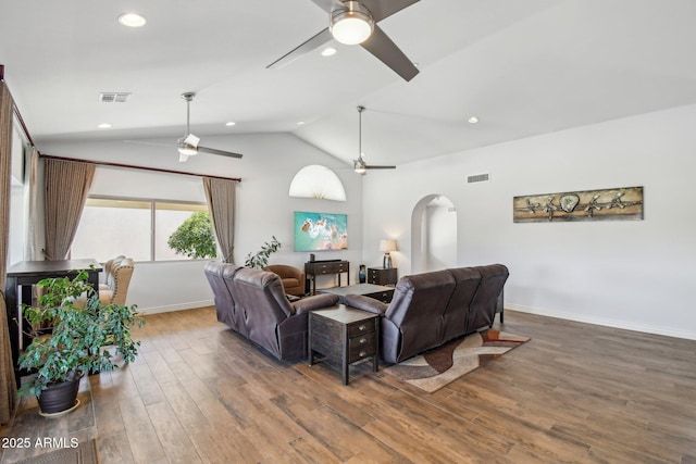 living room featuring visible vents, arched walkways, a ceiling fan, lofted ceiling, and wood finished floors