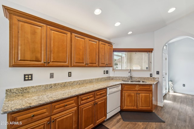 kitchen featuring dark wood-style floors, arched walkways, vaulted ceiling, white dishwasher, and a sink